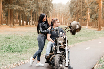 Obraz na płótnie Canvas guy with a girl in the park on a motorcycle