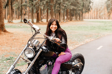 Plakat beautiful brunette riding a motorcycle in the park