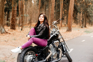 Fototapeta na wymiar beautiful brunette riding a motorcycle in the park