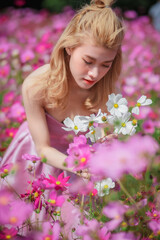 Beautiful girl in a field of cosmos flowers  on a sunny day