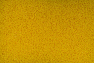 The rough texture of yellow plastic sponge scrubber with holes for background