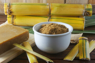 Handmade organic brown sugar granulated from sugarcane in bowl on wooden table of rustic refinery