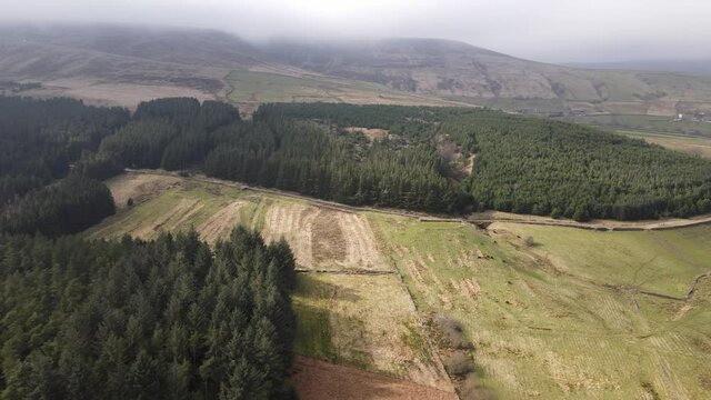 Aerial Drone View Forest Hike In Peak District West Yorkshire Holmfirth Yateholme With Walking trail and Misty Hills In Background