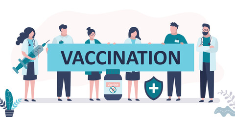 Medical staff holding poster with inscription vaccination. Women and men wears medical uniform