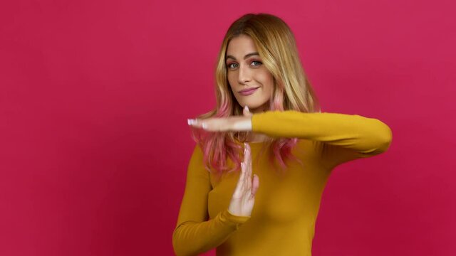 Young blonde woman doing time out gesture over isolated background