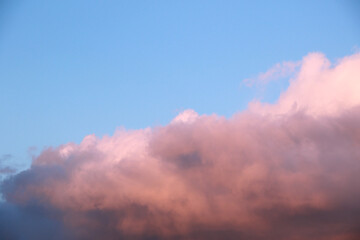 Fototapeta na wymiar blue sunset sky with heavy fluffy cumulus clouds