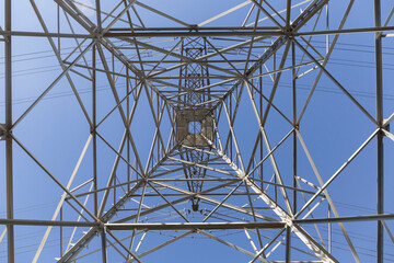 geometric shapes of the interior of an electrical tower seen from below, in the background you can see the blue sky