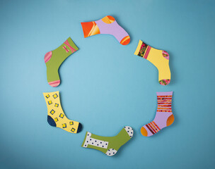 World Down Syndrome Day concept. Different socks made from paper on blue background.
