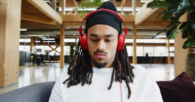 Young designer listening to music on
headphones at work
