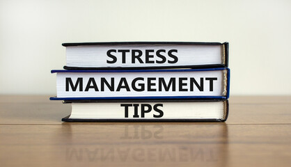 Stress management tips symbol. Books with words 'Stress management tips'. Beautiful wooden table, white background. Psychological, business and stress management tips concept. Copy space.