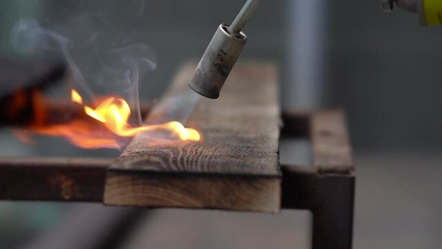 brushing wood with fire, burning wood with fire, burner