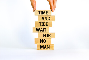 Time to action symbol. Wooden blocks with words time and tide wait for no man. Beautiful white background. Businessman hand. Business and time to action concept. Copy space.