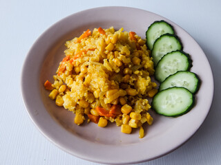 porridge made from a mixture of vegetables and cereals with cucumber slices on a plate