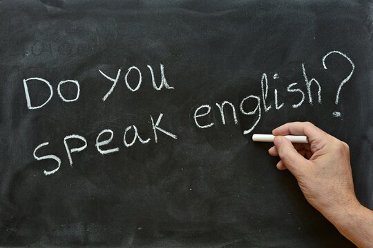 Mano escribiendo, do you speak english?, en una pizarra	
