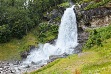 Fototapeta premium Steinsdalfossen Waterfall. Norway. Summer. Waterfall among the forest