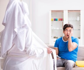 Obraz premium Young wife is trying to seduce husband from watching football an