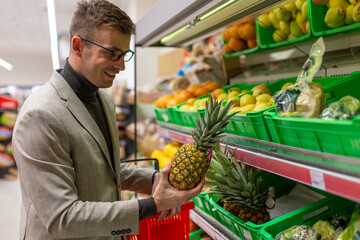 A businessman is buying fruits in the supermarket.