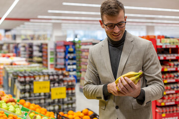 A businessman is buying fruits in the supermarket.