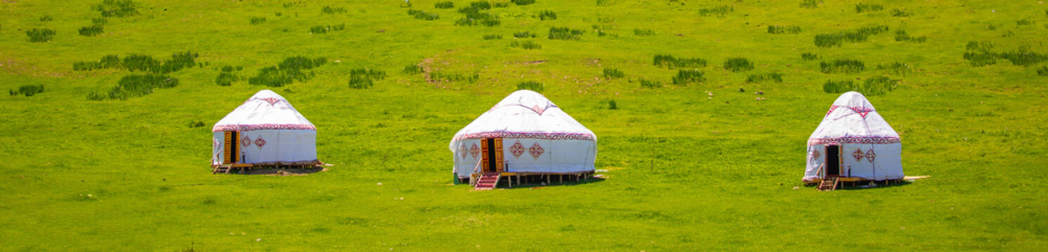 Yurt. National ancient house of the peoples of Kazakhstan and Asian countries. National Housing. Yurts on the background of a green meadow and highlands.