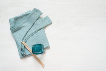 Mint color cotton shirt on the white wooden table background with copy space.