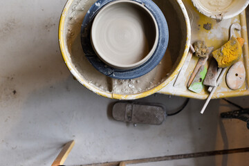 Fototapeta na wymiar Pottery wheel with ceramics tools for making art and craft objects from clay in a workshop studio