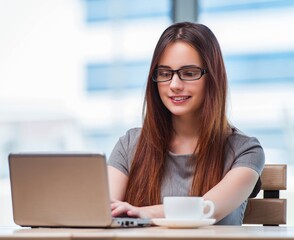 Young businesswoman drinking tea in office