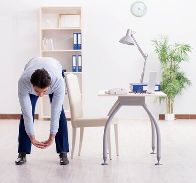 Employee Doing Stretching Exercises In The Office