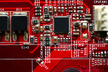 Red computer motherboard chip close-up with elements