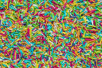 Tiny rod-shaped bits of candy used in the bakery as cakes topping. Rainbow sprinkles top view