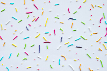 Fototapeta na wymiar Multicolored rod-shaped sprinkles isolated on white paper background