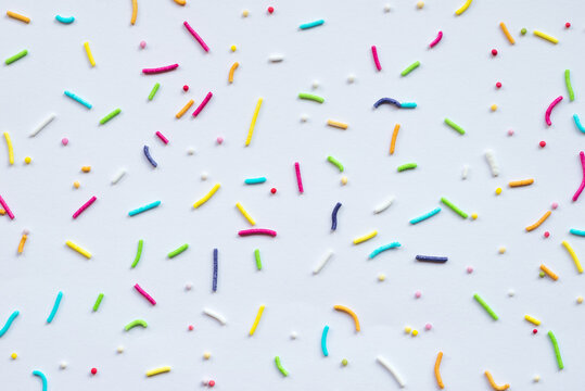 Multicolored rod-shaped sprinkles isolated on white paper background