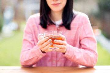 woman drinking tea in the garden in sunny day 