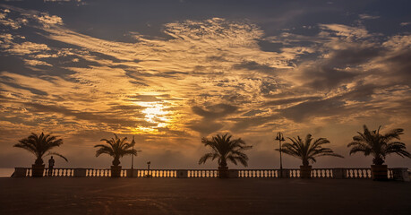 Dramatic sunrise on the beach in Burgas, Bulgaria. Sunrise on the Burgas Bridge. Bridge in Burgas - symbol of the city.