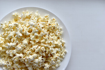 Delicious popcorn on a white plate close-up