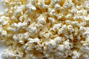 Delicious popcorn on a white plate close-up