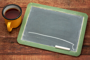 blank slate blackboard with white chalk  against rustic barn wood table with a cup of tea