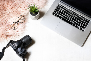 flat lay of workspace with laptop eyeglasses photo camera on white background