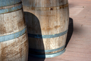 Fototapeta premium Wooden barrel close-up. Steel hoop on a wooden barrel, side view. View of a fragment of a wooden barrel on a sunny day.
