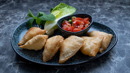Samosa is a fried or baked pastry with a savory filling, such as spiced potatoes, onions, peas, cheese, beef and other meats