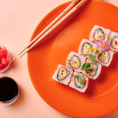 Colorful photo of sushi roll on red plate. Traditional japanese food served in fastfood restaurant. Sushi roll top view with wasabi and ginger