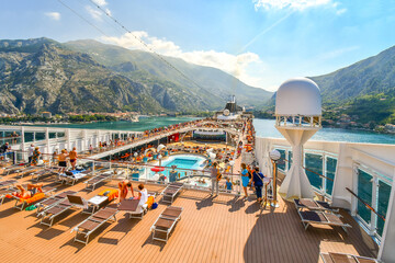 Tourists on a large cruise ship on Boka Bay near Perast heading towards the Kotor Montenegro cruise port on the Adriatic Sea. - obrazy, fototapety, plakaty