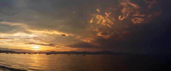 panoramic of the Sunset on a tropical beach with pirate boats in the background, located on the beach of Cachoeira do Bom Jesus, Canasvieras, Ponta das Canas, Florianópolis, Santa Catarina
