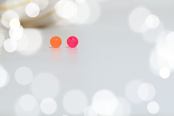 two small balls of orange and pink color on blurred background with bokeh around