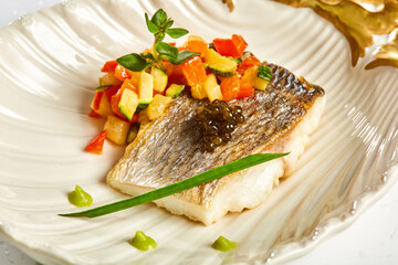 The white fish on plate with vegetables and decorated black caviar. Kosher food. Shallow dof