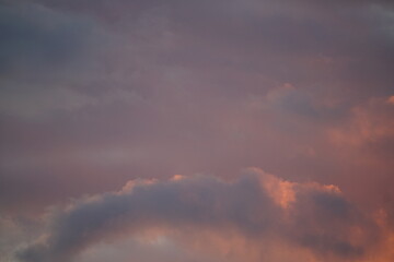 Fototapeta na wymiar Wolken Hintergrund in blauer und orangener Tönung bei einem Sonnenuntergang