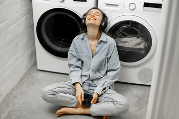 Woman enjoys music while washing clothes
