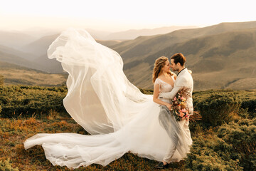 Beautiful happy smiling young couple in love hugging in the mountains, beautiful landscape wedding couple