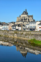 Fototapeta premium River in the town of Mayenne with Notre-Dame basilica , commune in the Mayenne department in north-western France