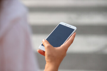 Girl's hand with smarthphone. Screen for mock-up