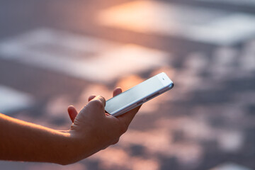 Pedestrian hand with phone crossing the road.Danger of distraction and traffic accident